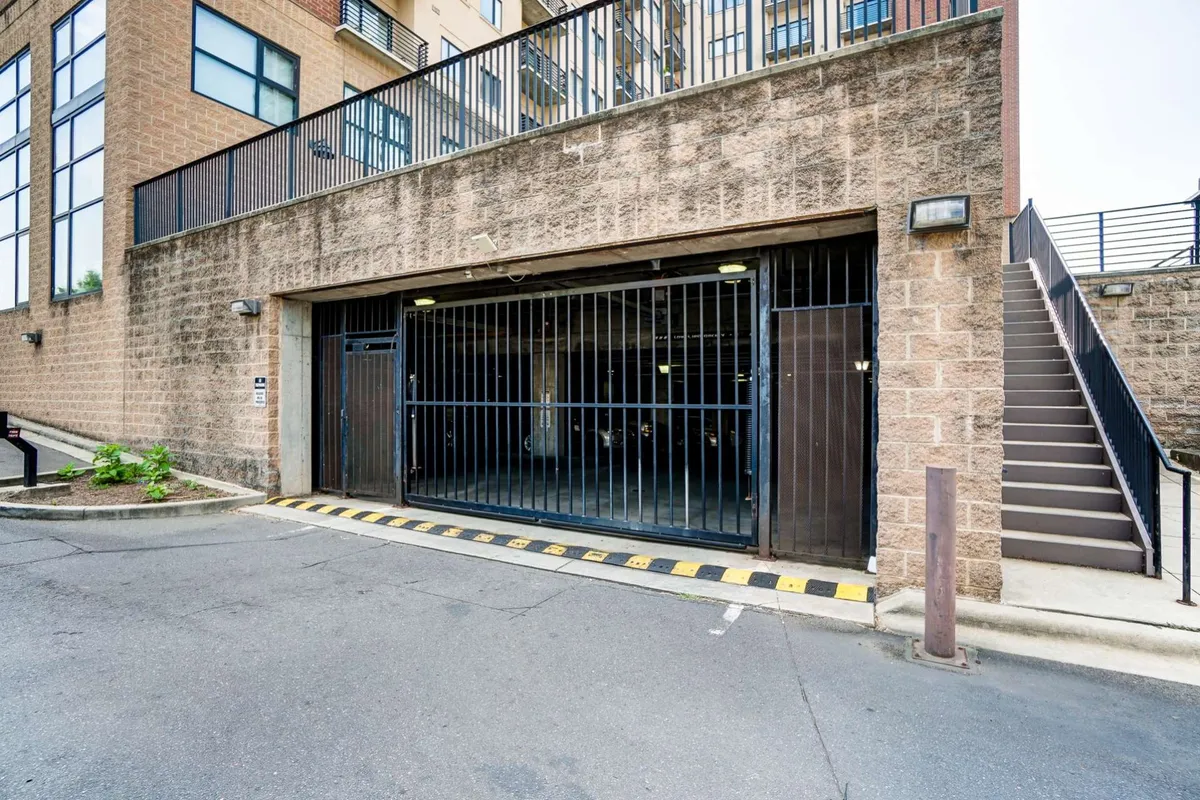 This image shows the exterior garage entrance with a staircase leading up to the building, surrounded by a neat planting area. The focus is on practical access points, highlighting how residents or guests enter and exit the property with ease.