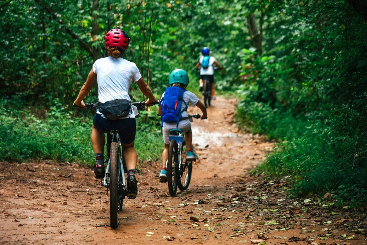 A cheerful scene with a family biking together along a dirt path surrounded by lush greenery. The image radiates a sense of exploration and joy, with the city’s nature easily accessible for outdoor activities and relaxation.